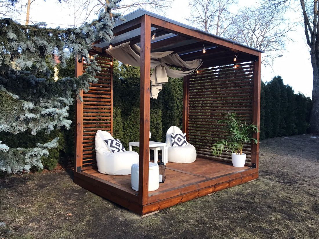 Wooden outdoor cabana with seating area and plants in a garden setting