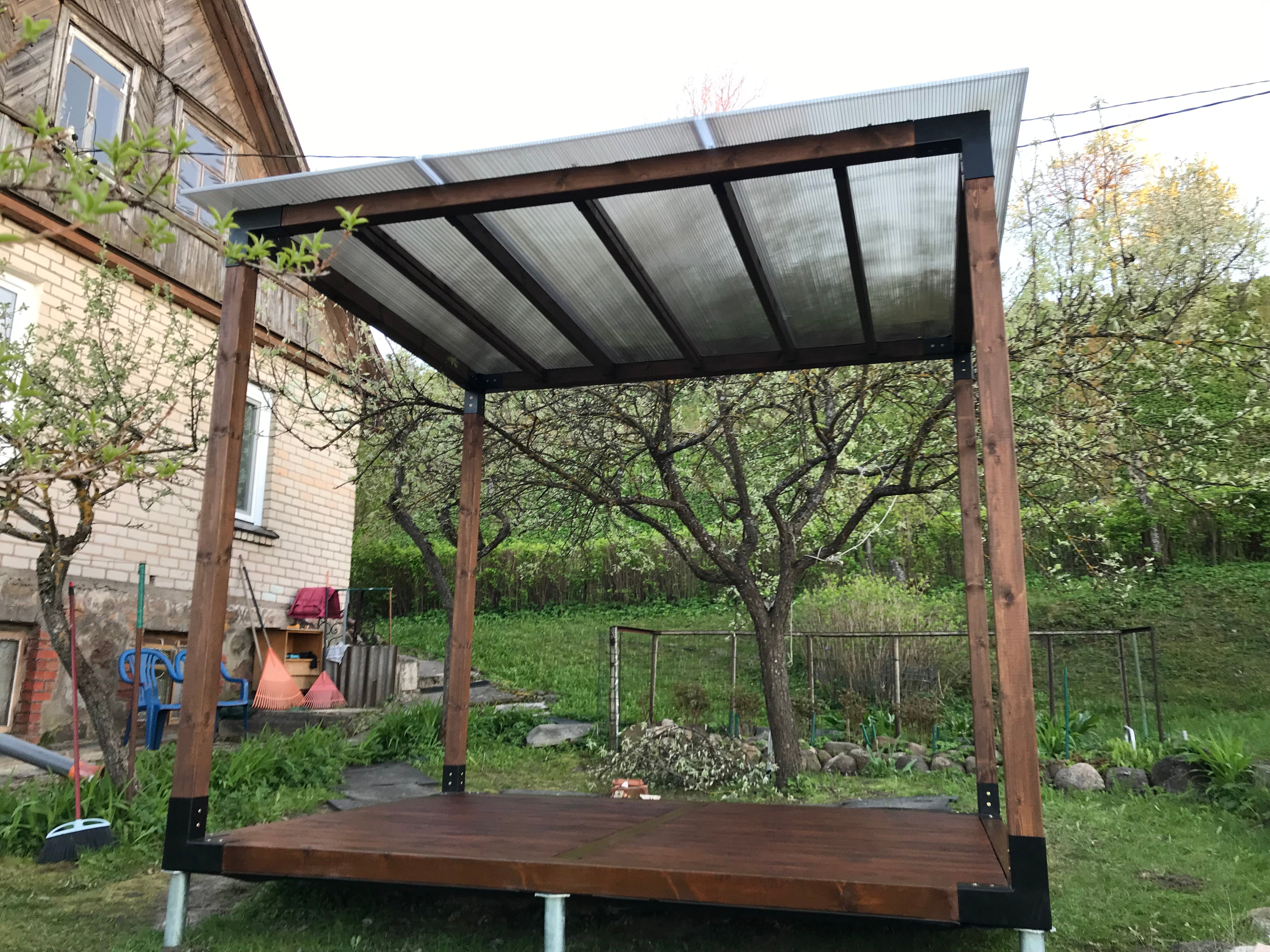 Wooden pergola with a polycarbonate roof in a garden setting
