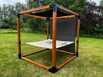 Outdoor pergola structure on a grassy area with trees in the background