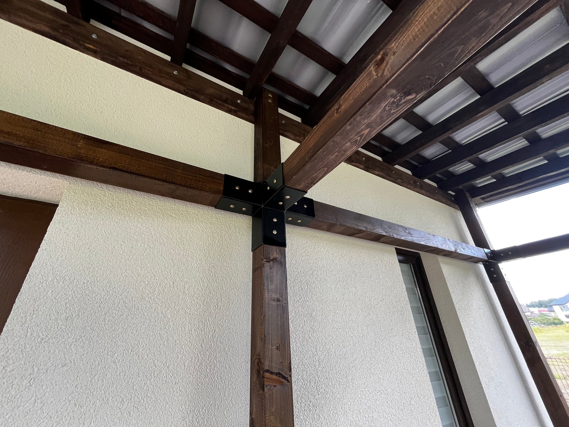 Wooden beams and ceiling structure with a window in the background