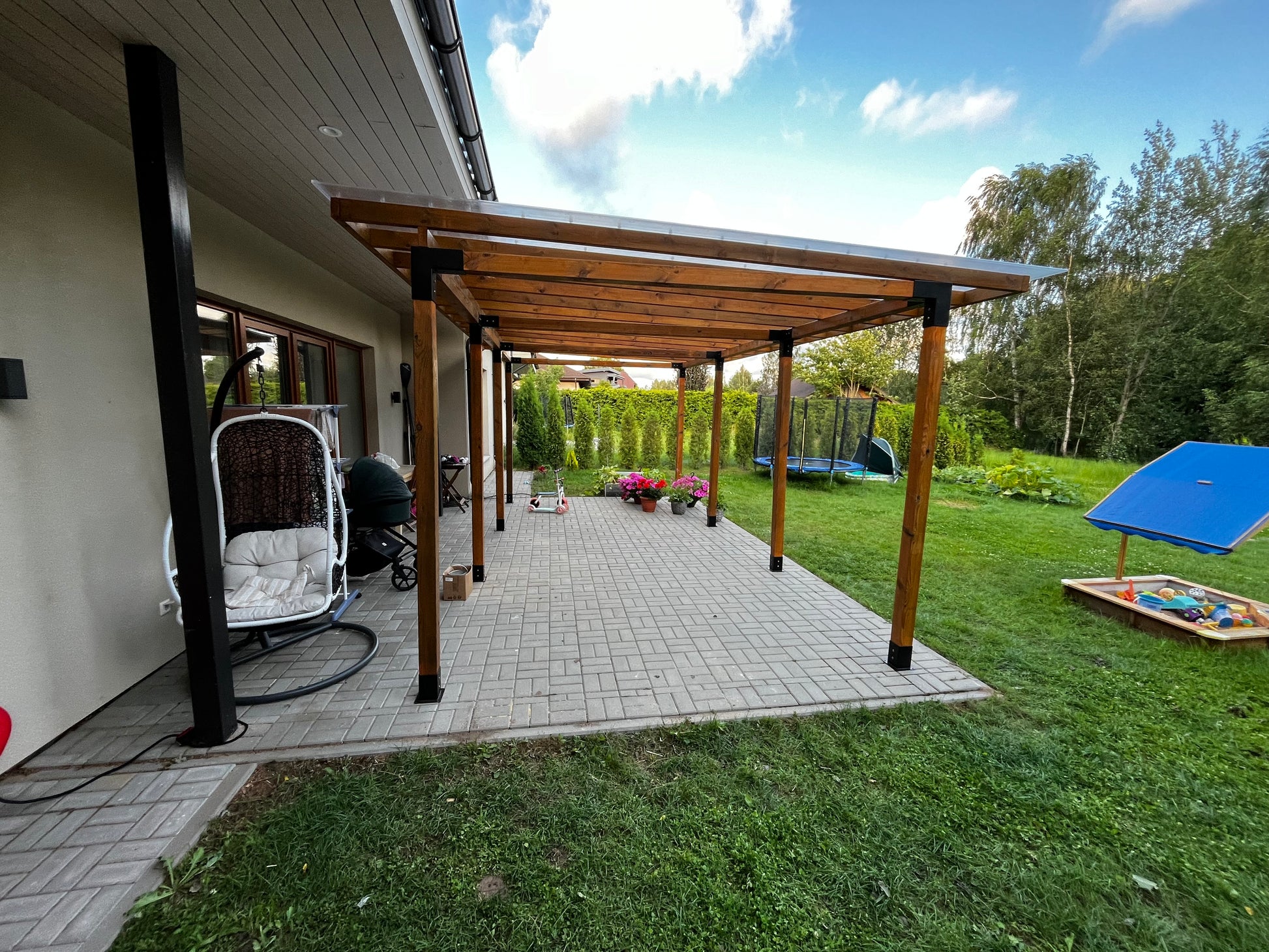 Backyard with wooden pergola, patio, and outdoor furniture
