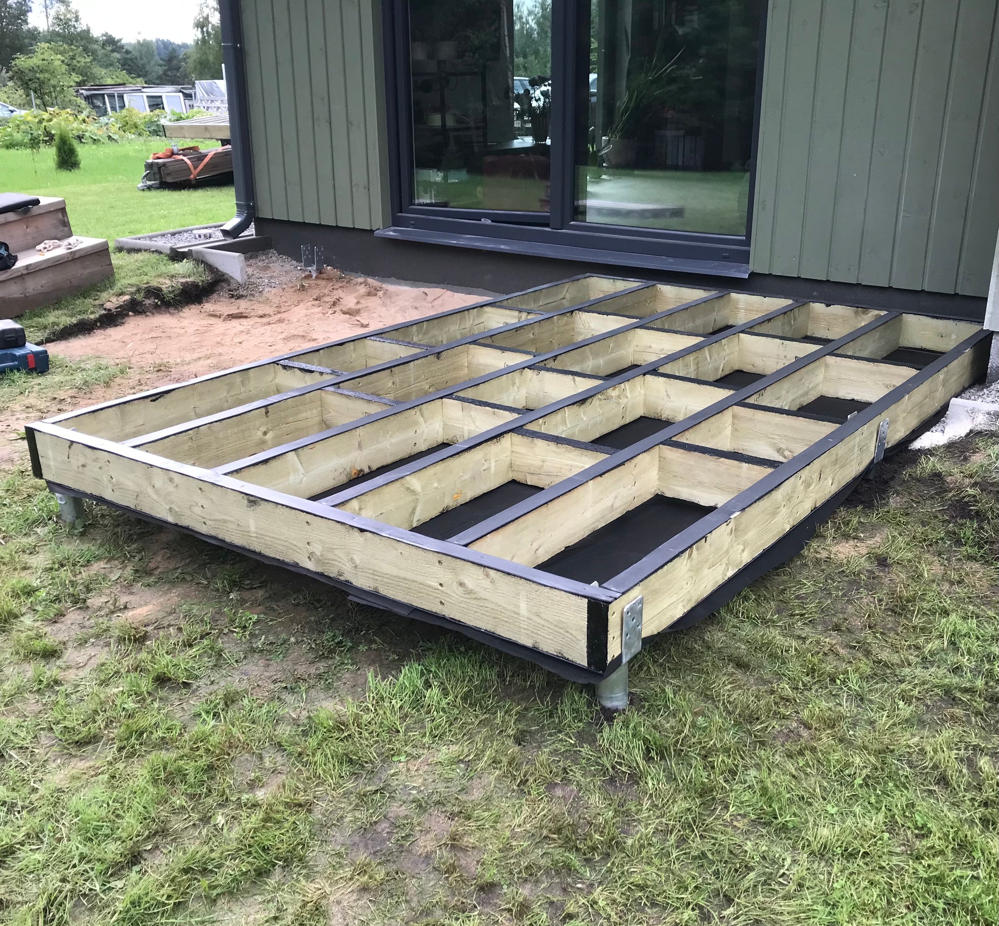 Wooden floor framework being built in front of a house
