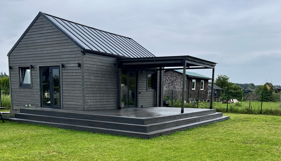 Wooden deck area of a modern house with a view of a rural landscape.