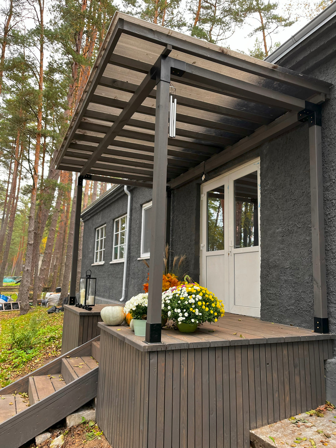 Modern house exterior with a wooden pergola and decorative elements.