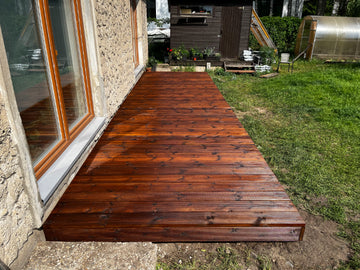 Wooden deck extending from a house with a garden